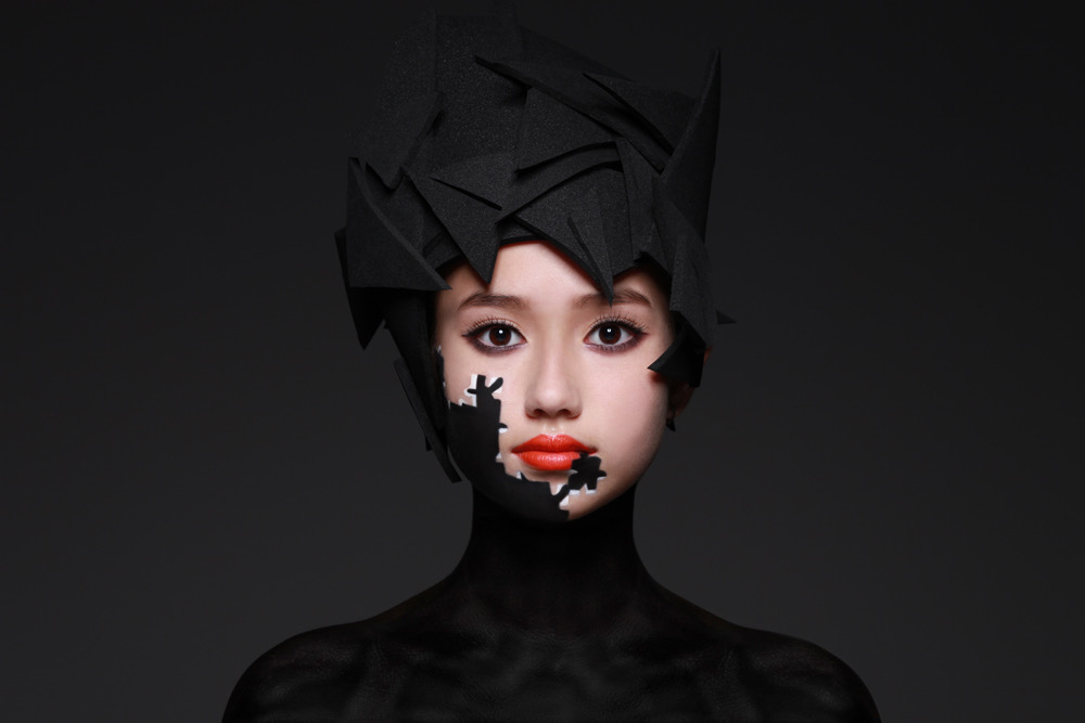 Creative editorial makeup with bold red lips, black geometric headpiece and floral face detail