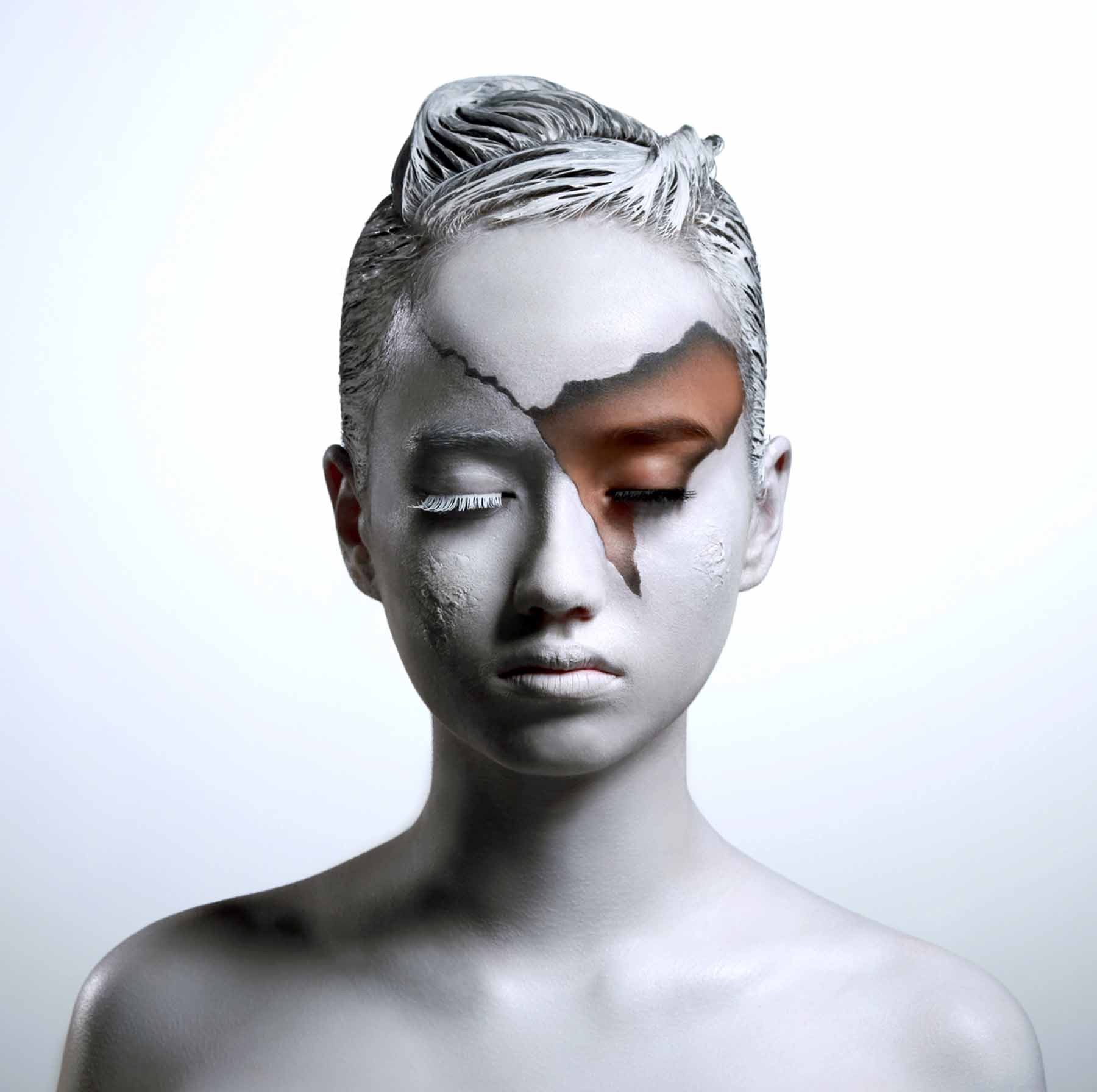 Sculptural silver editorial makeup, textured metallic skin and a contrasting natural eye
