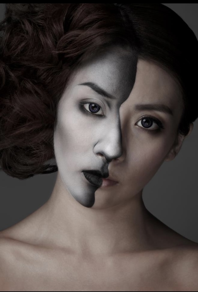 Graphic black and white makeup with a vertical dark stripe across the face