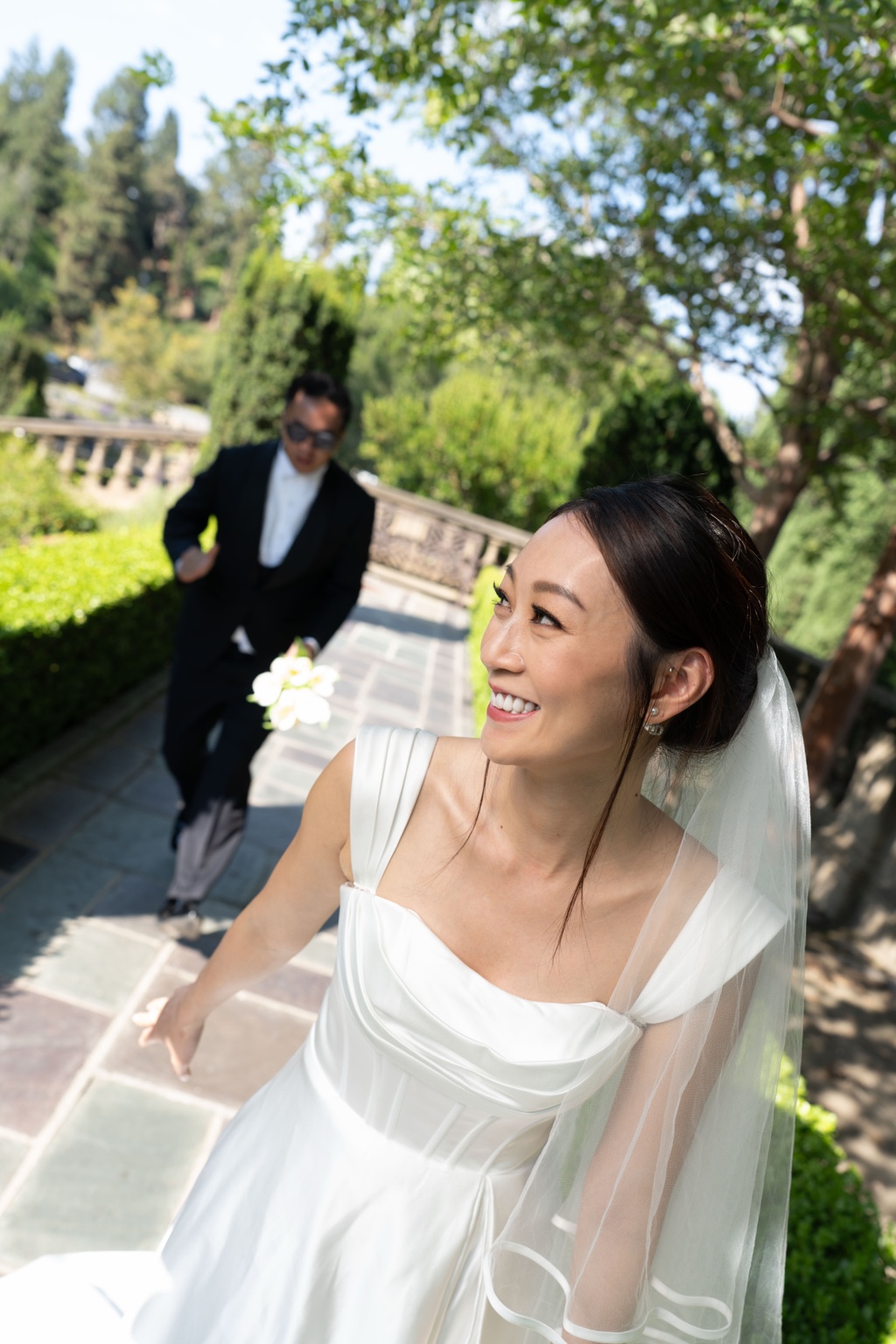 Bride in natural outdoor light with soft bridal makeup and a white veil